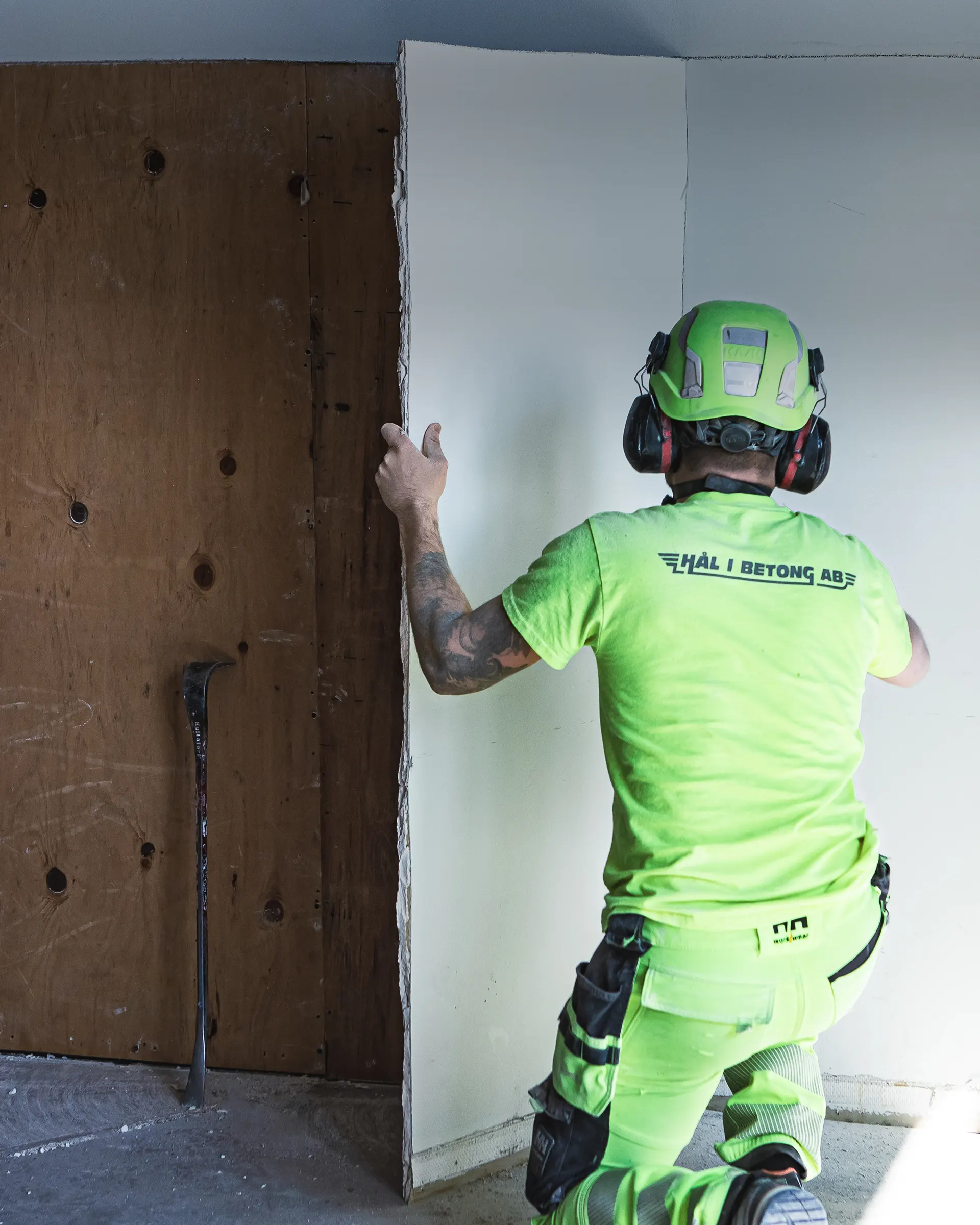 Man på arbetsplats som utför rivningsarbete.